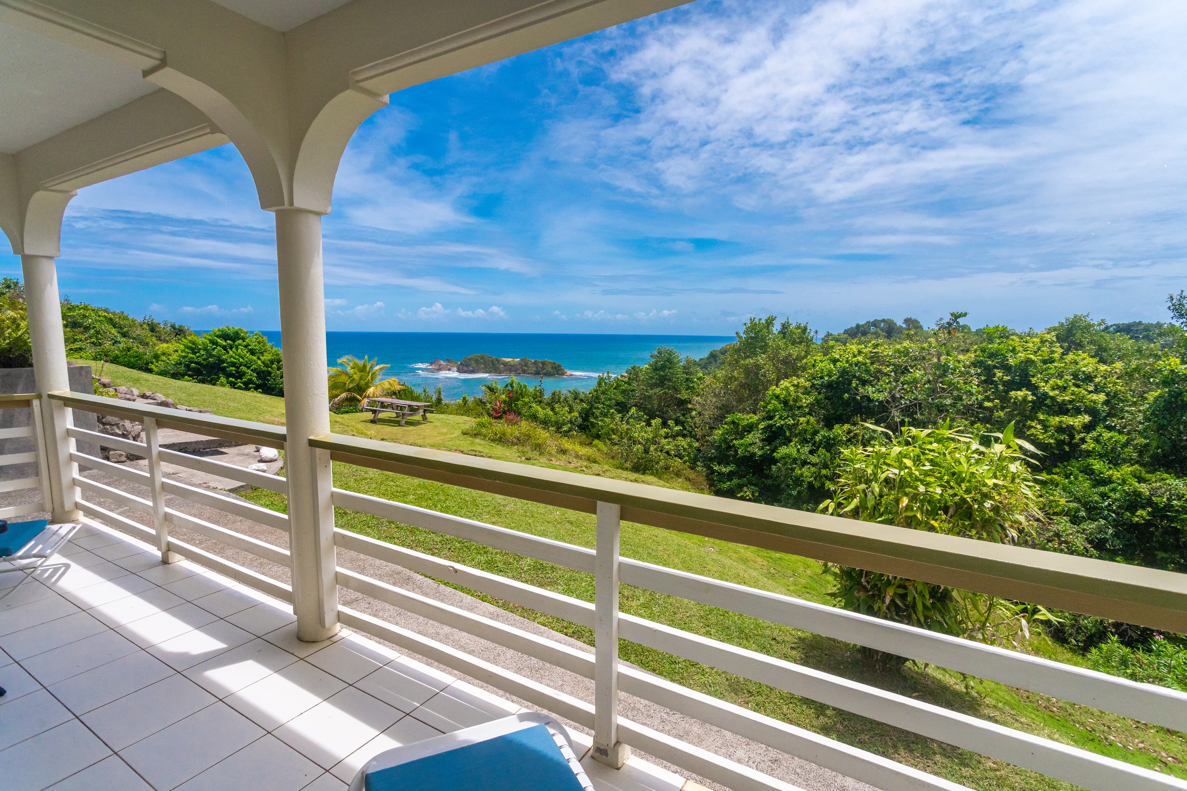Private balcony overlooking the ocean and rainforest coast at Bay View Lodges